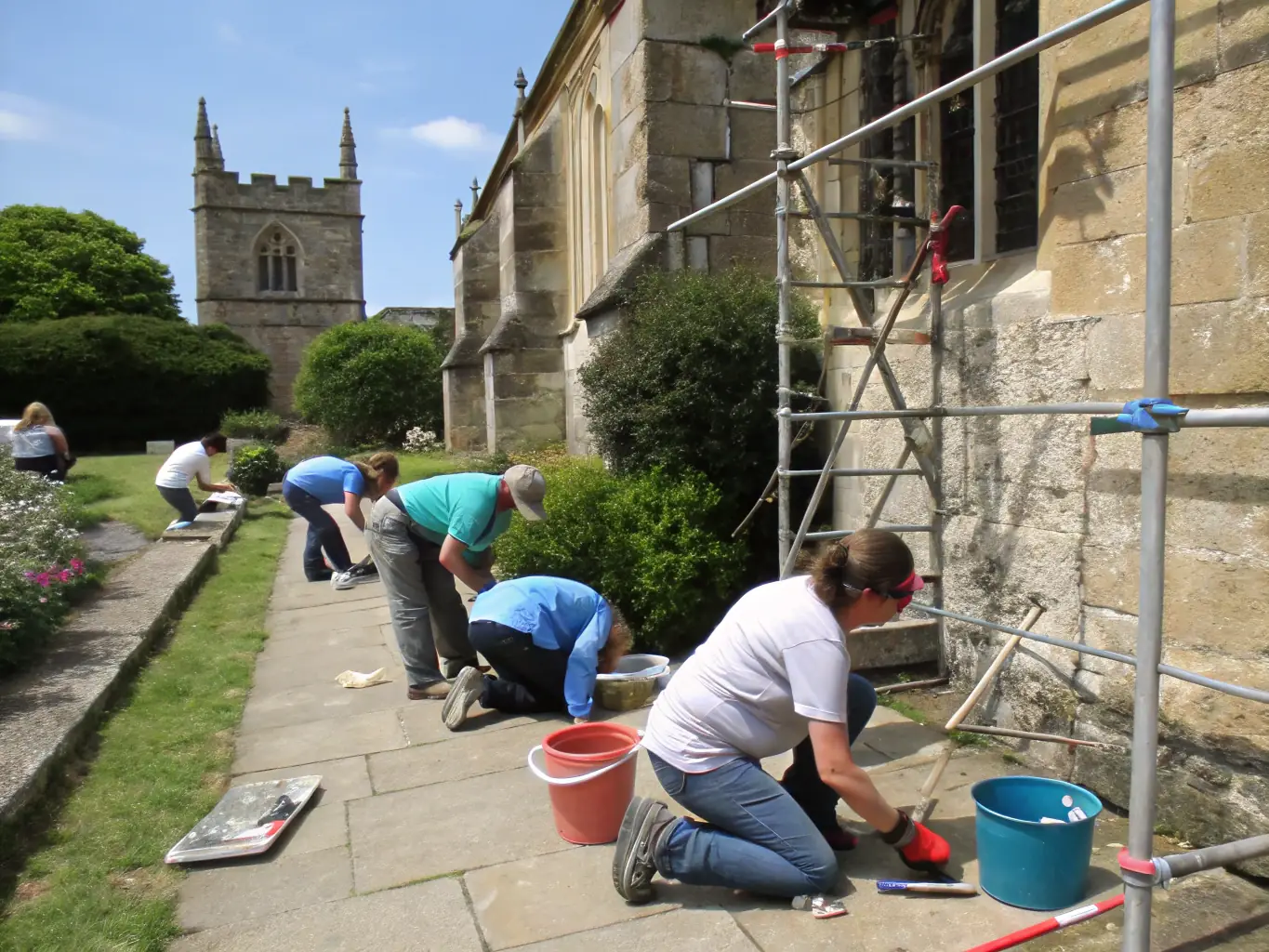 An image depicting a heritage preservation project, showing volunteers working on restoring a local historical site or artifact.